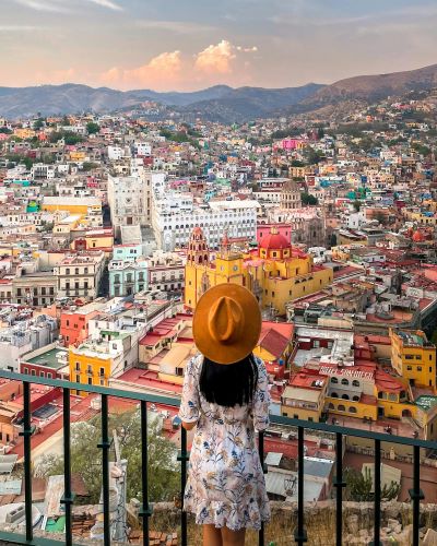 Backview of Woman in Floral Dress overlooking an Old City in Mexico Backview of Woman in Floral Dress overlooking an Old City in Mexico