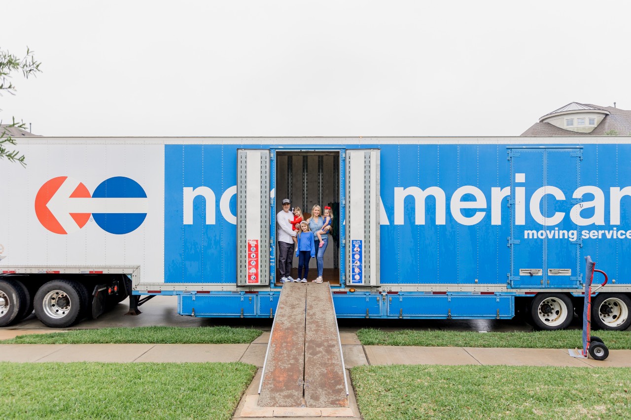 Family of five standing inside a North American Van Lines moving truck