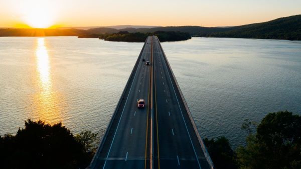 Cars driving on a bridge over large body of water Cars driving on a bridge over large body of water