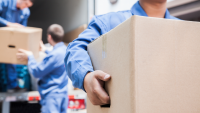 Workers removing moving boxes from a truck